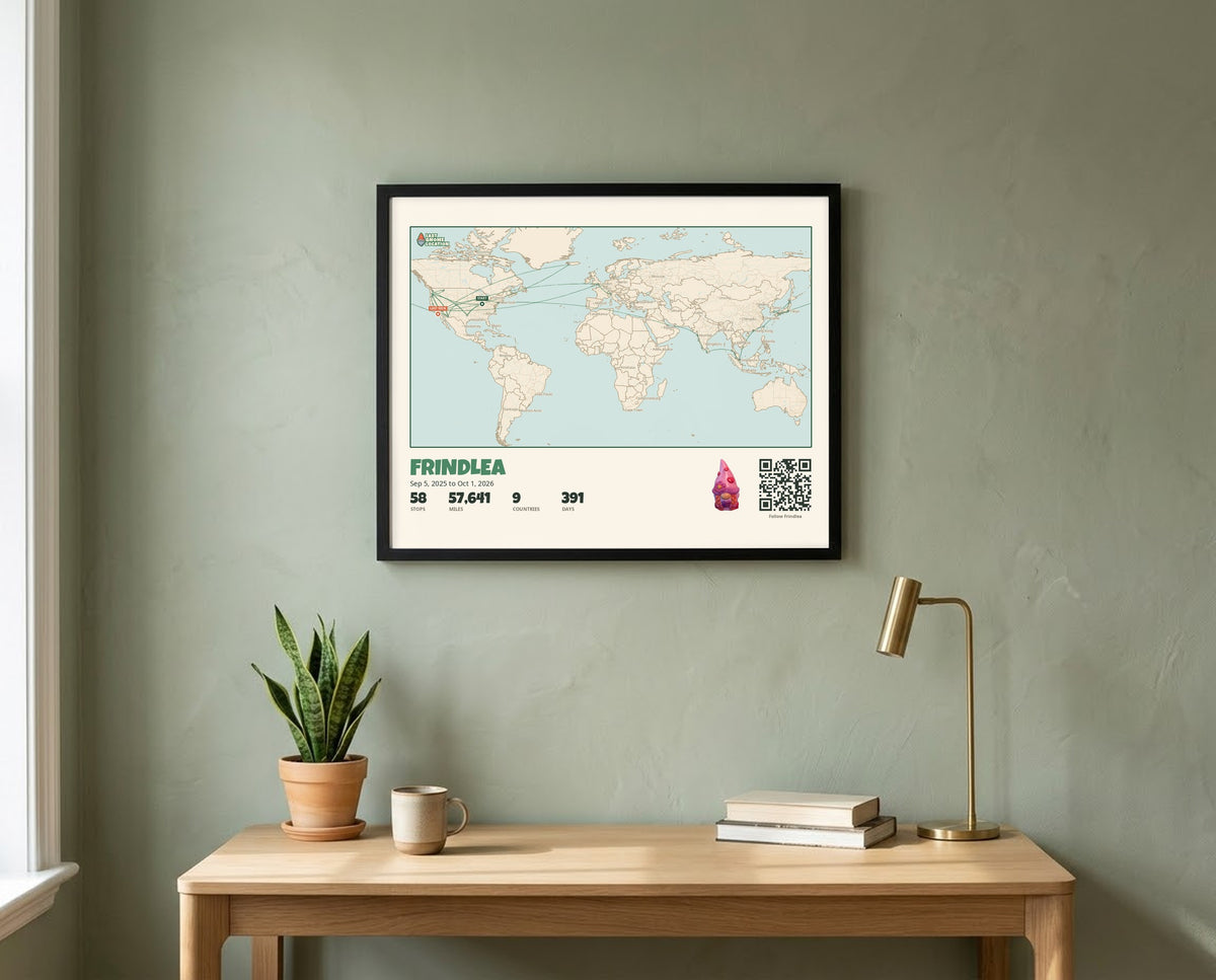 A landscape Gnome Journey Map poster for Frindlea, a world map of her travels, in a black frame above a desk
