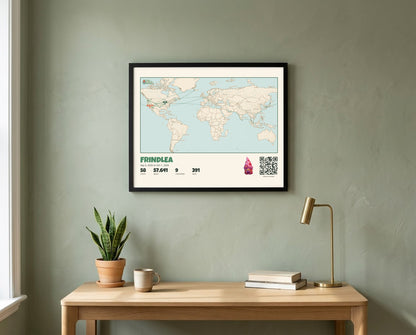 A landscape Gnome Journey Map poster for Frindlea, a world map of her travels, in a black frame above a desk